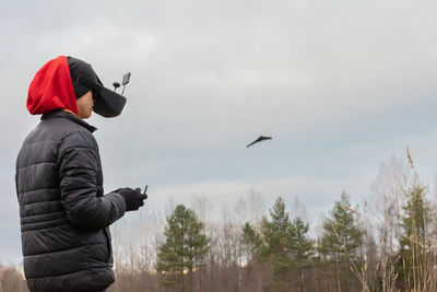 Young man launches rc plane into sky. teenager with glasses playing with toy 