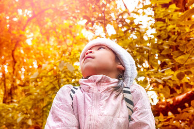 Portrait of young woman standing against plants