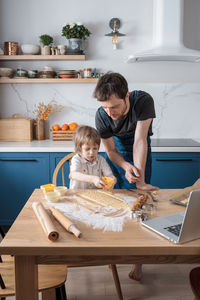 Cute preschool boy and his father baking cookies for international space day 