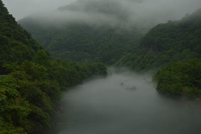 Scenic view of river amidst mountains against sky