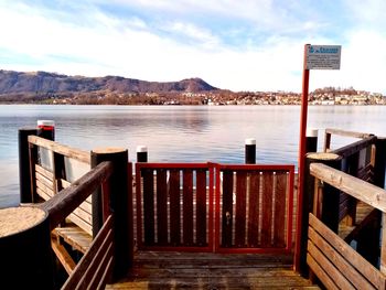 Wooden pier over lake against sky