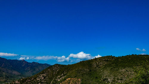 Scenic view of mountains against blue sky