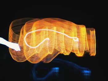 Close-up of illuminated lighting equipment against black background