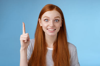 Portrait of a smiling young woman against blue background