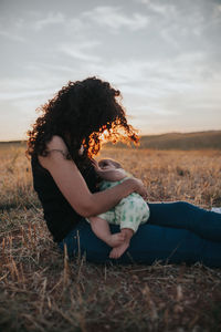 Side view of woman sitting on field