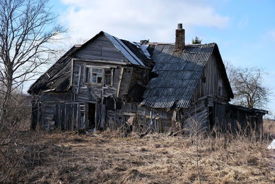 Abandoned house on field against sky