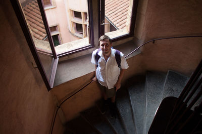 High angle portrait of man standing on staircase