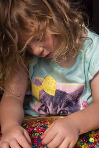 A child plays with colorful and shiny beads