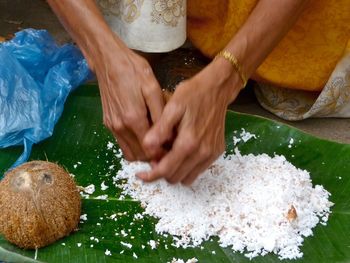 Cropped hands of woman grating coconut