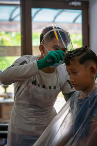 Portrait of boy looking through window