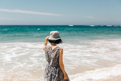 Rear view of man standing on beach