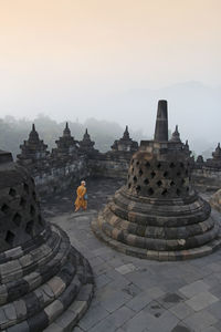 Stupas of building against sky during foggy weather
