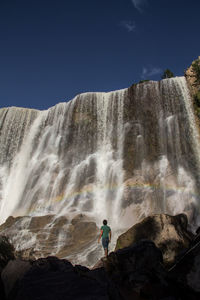 Man in front of waterfall