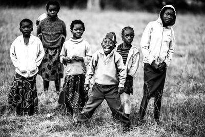 Full length portrait of boys standing on field