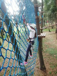 Full length of woman standing on tree trunk