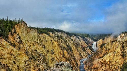 Scenic view of rocky mountains against cloudy sky