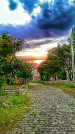 View of footpath against cloudy sky