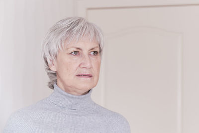 Portrait of mid adult woman against wall