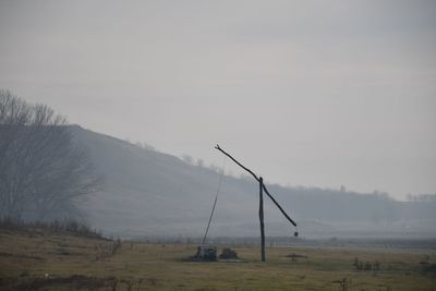 Windmills on field against sky