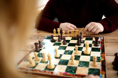 Full length of man playing with stuffed toy on chess board