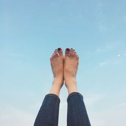 Low section of woman against blue sky