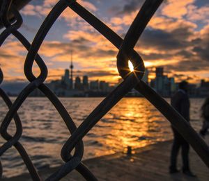 Close-up of chainlink fence at sunset