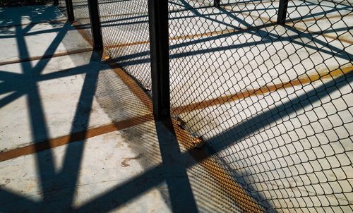 High angle view of shadow of fence on sunny day