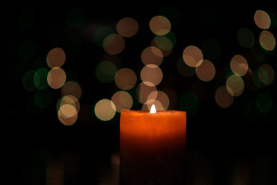 Close-up of burning candle in darkroom