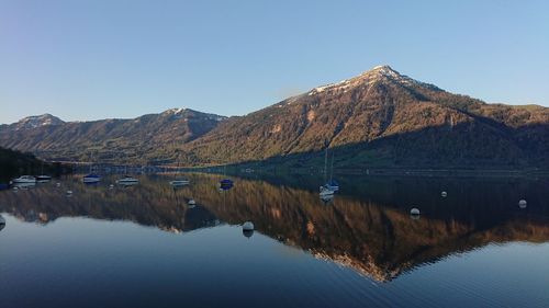 Reflection of mountains in lake against clear blue sky