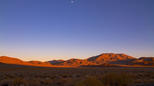 Scenic view of desert against blue sky