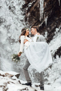Couple kissing in snow during winter