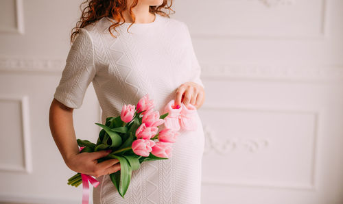 Midsection of woman holding white rose