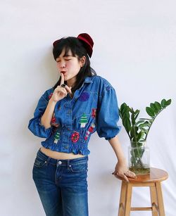 Full length of girl standing against wall