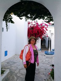 Portrait of smiling woman standing against wall