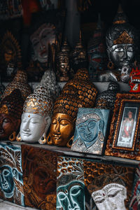 Handmade gold plated buddha face masks on a counter in a street shop on the island of bali