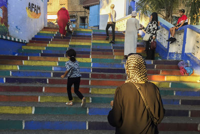 Rear view of people walking on staircase