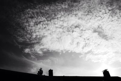 Low angle view of silhouette trees against sky