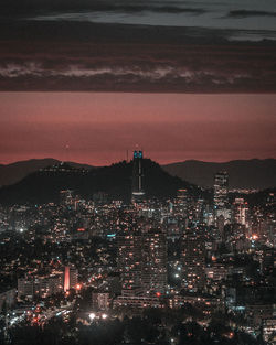 High angle view of illuminated buildings against sky at night