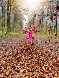 Full length of woman with leaves on tree during autumn