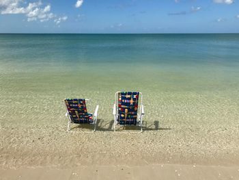 Lifeguard chair on beach against sky
