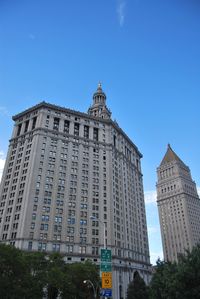 Low angle view of office building against blue sky