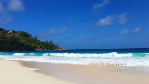 Scenic view of beach against blue sky