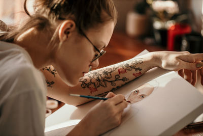 Side view of girl painting at workshop