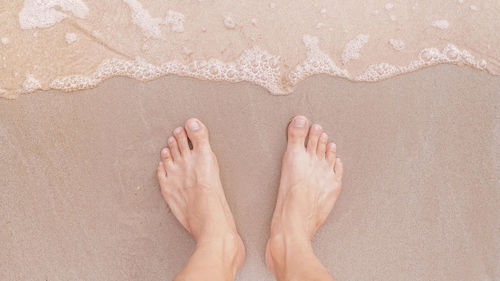 Low section of woman standing on beach