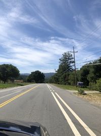 Road by trees against sky seen through windshield