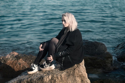 Woman sitting on rock at beach