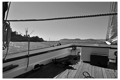 Boats moored at harbor against clear sky