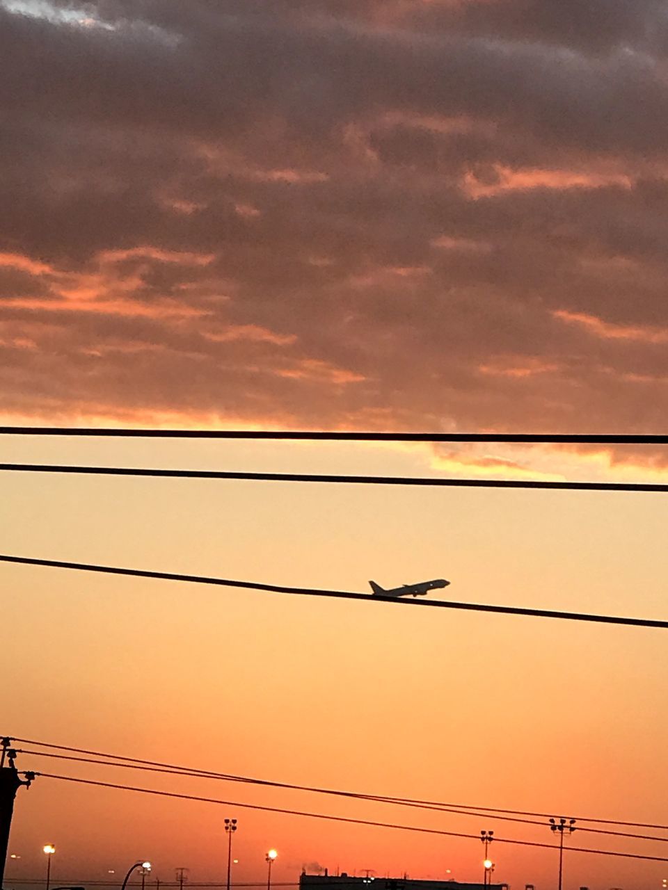 LOW ANGLE VIEW OF SILHOUETTE AIRPLANE FLYING AGAINST DRAMATIC SKY