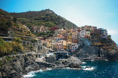 Townscape on mountain by sea against sky