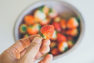 Midsection of person holding strawberry